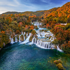 Krka, Croatia - Aerial panoramic view of the beautiful Krka Waterfalls in Krka National Park on a bright autumn morning with colorful autumn foliage and blue sky