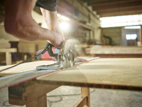 Carpenter cutting oriented strand board with circular saw