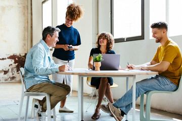 Happy business colleagues discussing and working together in office