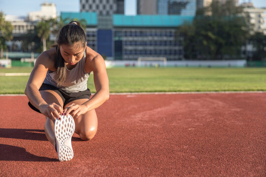 Young Woman Exercising In Sports Field