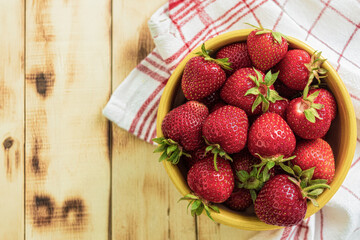 Fresh strawberries on a wooden table, close-up. View from the mountain