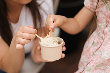 Close-up of mom and daughter eating ice cream. Delicious sweets