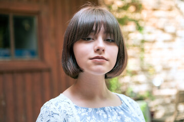 Sad teen girl on a summer street. Close-up portrait of beautiful teen girl on the street.