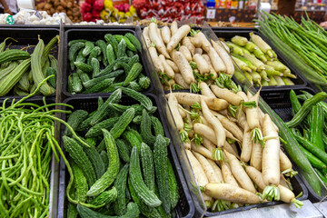 Fresh ripe tasty daikon and chinese cucumber are sold on the market in boxes