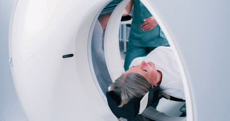 Close-up back shoot of woman going out of MRI capsule. Patient is finished magnetic resonance...