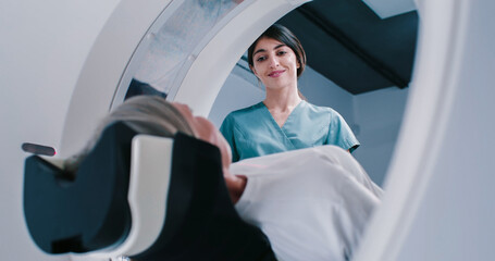 Female finished magnetic resonance imaging, Patient is moving out of MRI scanner capsule. Female...