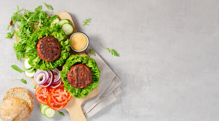 Freshly Grilled Burger Patties,Plant Based Meatless Burgers with Fresh Vegetables on a Wooden Board on Bright Background