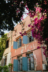 Street view with old medieval historic buildings and flowers in small town in Greece, Crete. Traditional European, Greek architecture. Summer travel