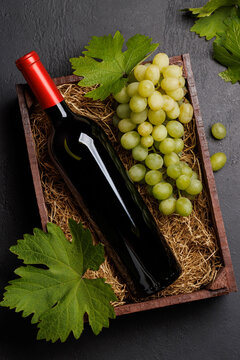 A red wine bottle and fresh grapes