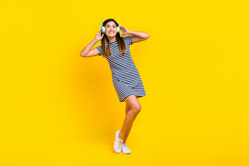 Fototapeta na wymiar Full body photo of young chinese lady touch wireless headphones rest listen itunes music have fun isolated on yellow color background
