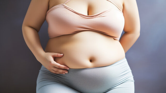 Body of a woman close-up view showing a belly with fat pad , obesity concept