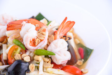 Spicy papaya salad with seafood on the white background.