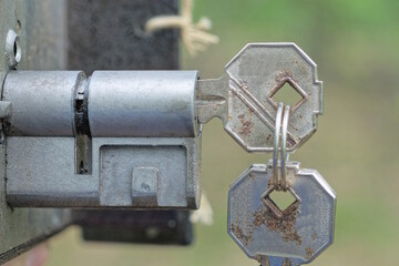 one old gray rusty metal key in the core of the lock