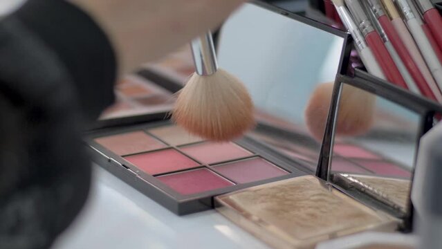 brush on eye palette makeup, brushing blush pastel make-up tints, blush palette, close-up shot, mirror reflection, artistic professional cosmetics salon, MUA make up artist.
