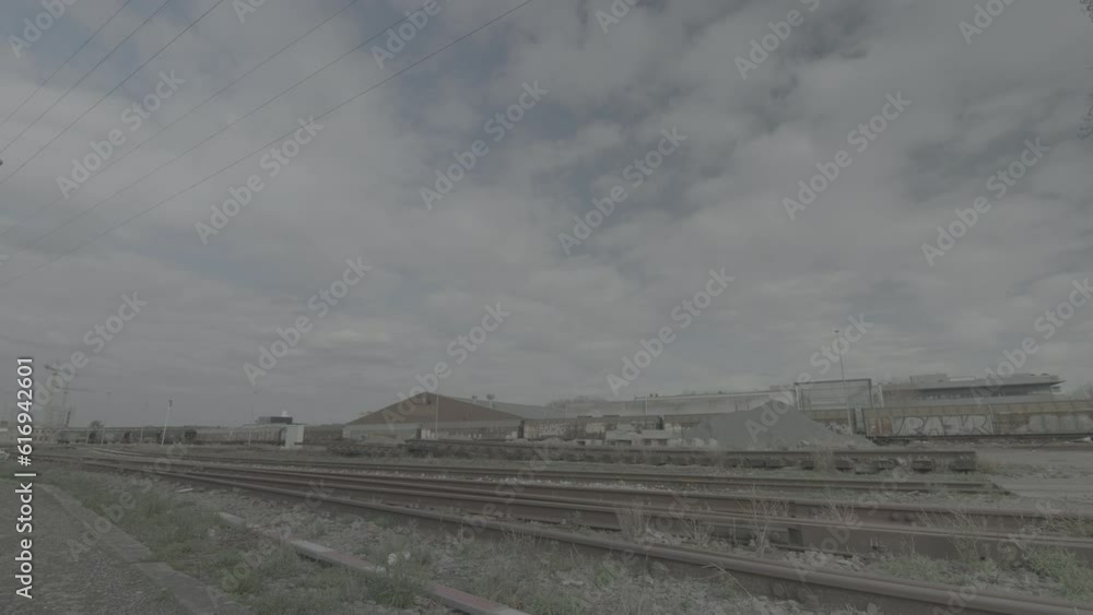 Poster timelapse of a deserted railroad station in belgium with moving clouds creating shadows on the groun
