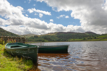 Rowing boats on Watendlath Tarn, Lake District, Cumbria, UK.  The tarn  sits high between the...