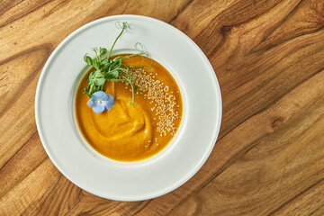 Vegetarian carrot ginger or pumpkin cream soup in a plate