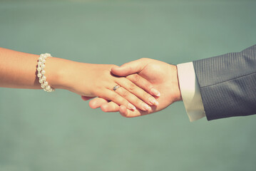 hands of husband and bride on a blurred background, isolated object