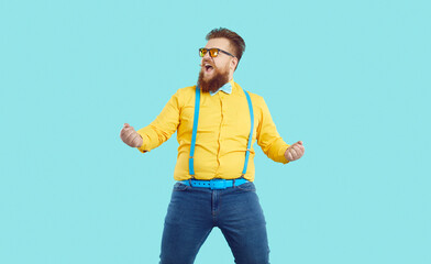 Happy excited chubby young man having fun. Funny crazy ecstatic fat ginger bearded guy in yellow...
