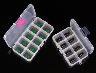 boxes with green and black pills isolated on black background, box for tablets, box for vitamins