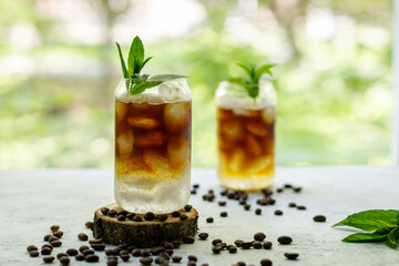 Cold black coffee with tonic and ice in glass. Summer drink on nature background