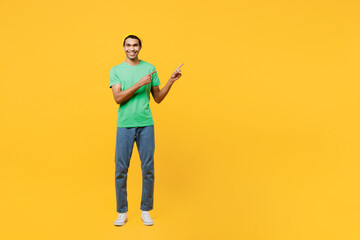 Fototapeta na wymiar Full body young man of African American ethnicity he wears casual clothes green t-shirt hat showing thumb down dislike gesture isolated on plain yellow background studio portrait. Lifestyle concept.