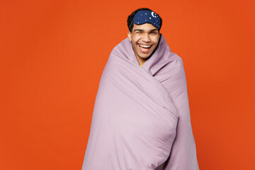 Calm young smiling happy man wear pyjamas jam sleep eye mask wrapped in purple blanket wink sleep...