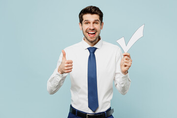 Young smiling fun employee IT business man corporate lawyer wear classic formal shirt tie work in office hold in hand check mark show thumb up isolated on plain pastel blue background studio portrait.