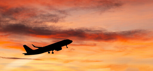 The plane takes off at sunset.