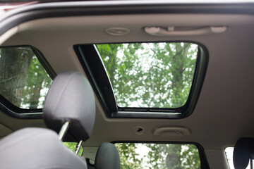 Panoramic sunroof at the car and blue sky. Clean sunroof and view of the sky from the inside or car interior