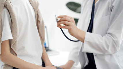 Doctor and a kid patient. Physician is holding stethoscope and ready to examine boy. Perfect health concept in medicine