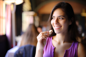 Happy woman eating some bread in a restaurant