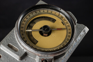 Old mining compass on dark background close up