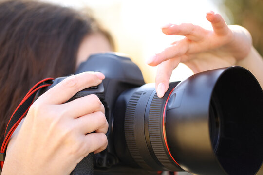 Photographer hand adjusting focus manually