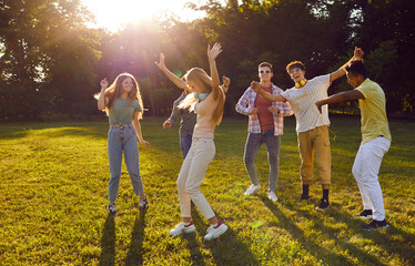 Friendship and carelessness. Group of young male and female friends have fun and dance at picnic...