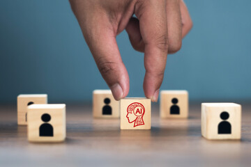 Human hand holding a wooden block with the word AI. Concept. Conversation with artificial intelligence. AI technology changes the world, including AI that causes people to lose their jobs, etc.