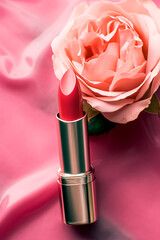 Obraz na płótnie Canvas Pink lipstick in a golden tube and blooming rose flower, beauty cosmetic and make-up product, generative ai
