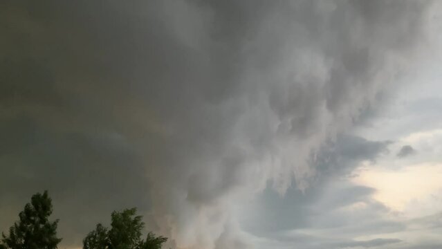 Arcus cloud, Roll clouds Shelf clouds - menacing thundercloud moving over trees in stormy summer day with hot weather. Visible thunderstorm with wind and rain.