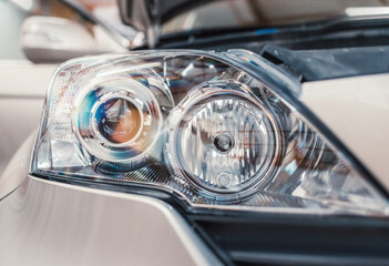 Car headlight in workshop. Repairing, polishing, tinting in garage, washing in carwash service.