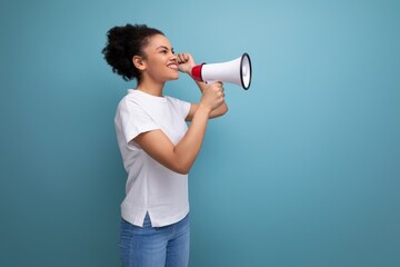 young hispanic brunette woman dressed in a white t-shirt shouting a message through a megaphone