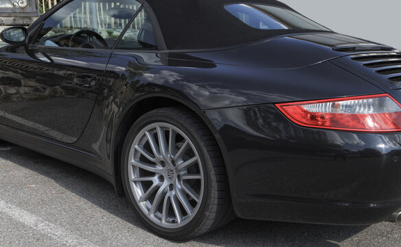 Close-up of the rear of the Porsche, bonnet, air vents, tire, door, rims with logo