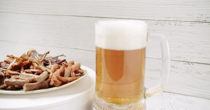 Craft Beer into the large glass. Beer Mug. On a white background. Half a liter, close up. Rotation 360 degrees. Glass full of beer with plate minced meat, and snacks. bbq meat set for beer snack. 