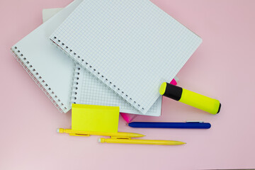 Notebooks with pens, markers and stickers on a pink background. Back to school business meeting. Copy space