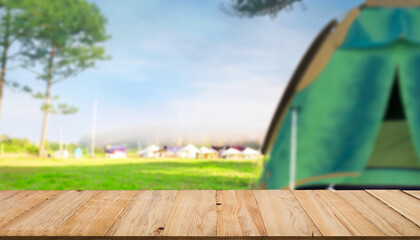 Wood table and Blurred camping and tents in forest.