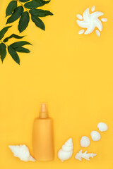 Suntan lotion for summer skincare protection with abstract starfish sun on yellow background with seashell soaps, decorative leaves and shells. Anti cancer concept.
