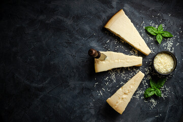Parmesan cheese. Hard cheese on a dark background. banner, menu, recipe place for text, top view.