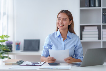 Beautiful young business woman manager or company worker holding accounting document, checking...