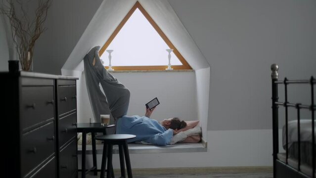 Woman reads e-book in her cozy apartment, 4k