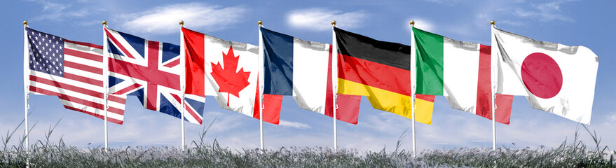 Seven flags of the Group of Seven are developing against the blue sky. G7