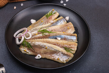 Fillet of pickled marinated sea herring fish with shallots and dill. Cutlery, vintage napkin